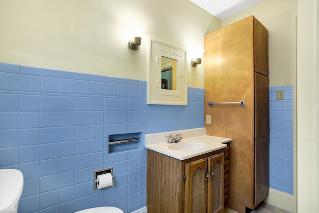 bathroom with vanity, tile walls, and toilet