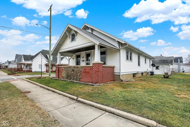 bungalow featuring covered porch, a front lawn, and central air condition unit