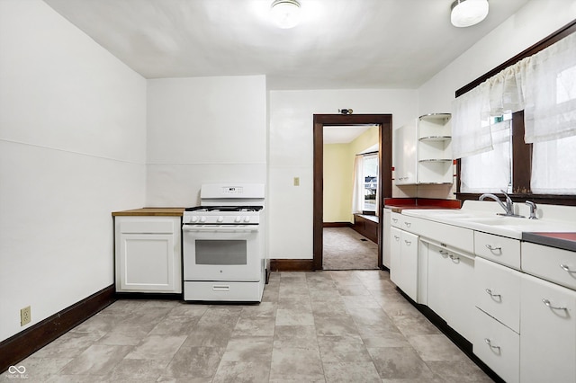 kitchen with white cabinetry, sink, and white gas stove