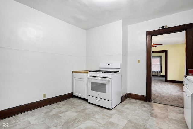 kitchen with white cabinetry, light colored carpet, and white gas stove