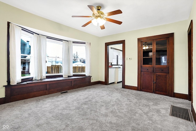 interior space featuring light carpet and ceiling fan