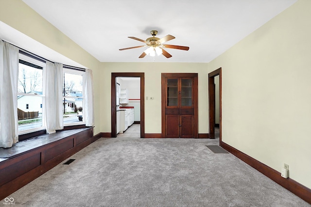 spare room with light carpet and ceiling fan