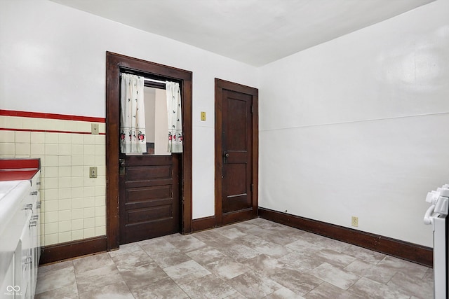 foyer entrance featuring tile walls