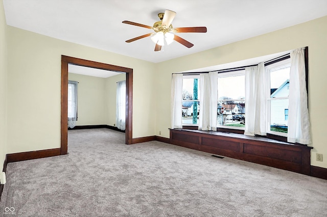 carpeted spare room with ceiling fan