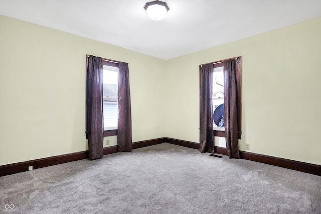 spare room featuring light colored carpet and a wealth of natural light