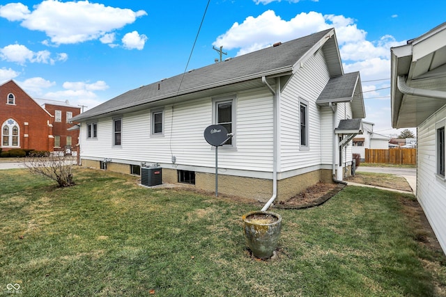 view of side of home featuring central AC and a lawn