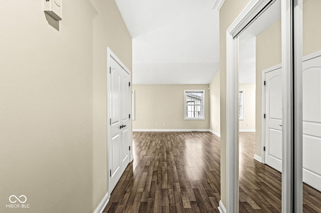 hallway featuring dark wood-type flooring and lofted ceiling