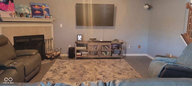 living room featuring a tile fireplace and hardwood / wood-style floors