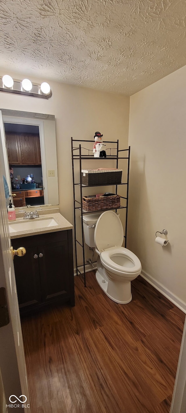 bathroom with vanity, hardwood / wood-style floors, a textured ceiling, and toilet