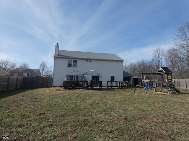 back of property with a gazebo, a lawn, and a playground