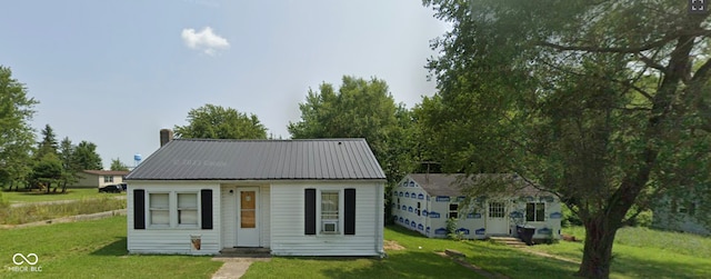 210 N Wayne St, Van Buren, IN 46991 - view of front of house featuring a front yard, metal roof, an outbuilding, and a chimney