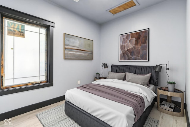 bedroom with multiple windows and light wood-type flooring