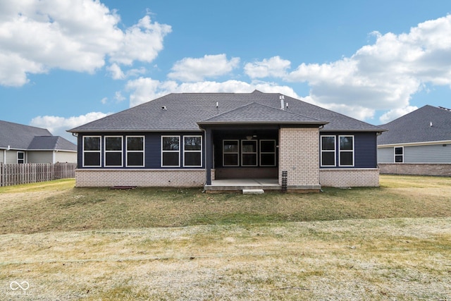 rear view of property featuring a lawn and a patio area