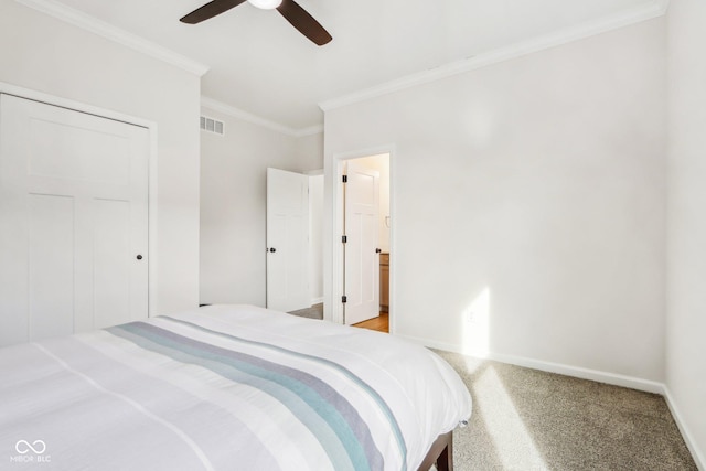 bedroom featuring ornamental molding, carpet, ceiling fan, and a closet