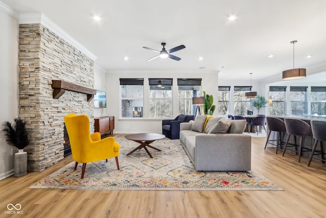 living room with light hardwood / wood-style flooring, ornamental molding, and ceiling fan