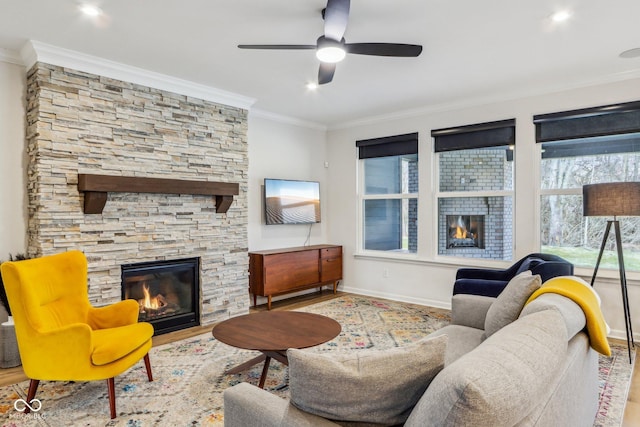 living room featuring crown molding, ceiling fan, a fireplace, and light hardwood / wood-style floors