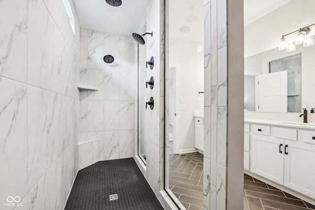 bathroom with tiled shower and vanity