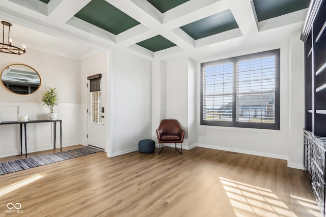 unfurnished room featuring coffered ceiling, hardwood / wood-style flooring, beamed ceiling, and a chandelier