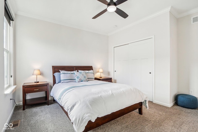 bedroom with ceiling fan, ornamental molding, carpet flooring, and a closet