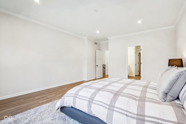 bedroom featuring ornamental molding and light wood-type flooring