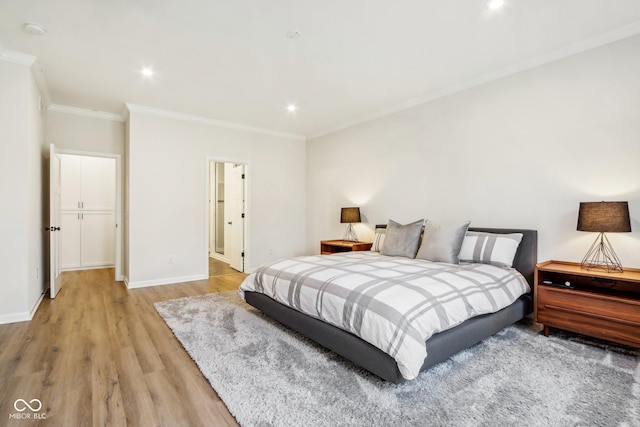 bedroom featuring crown molding and light hardwood / wood-style flooring