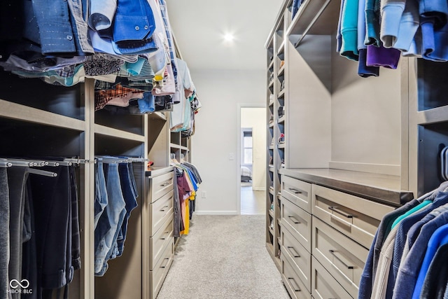 walk in closet featuring light colored carpet