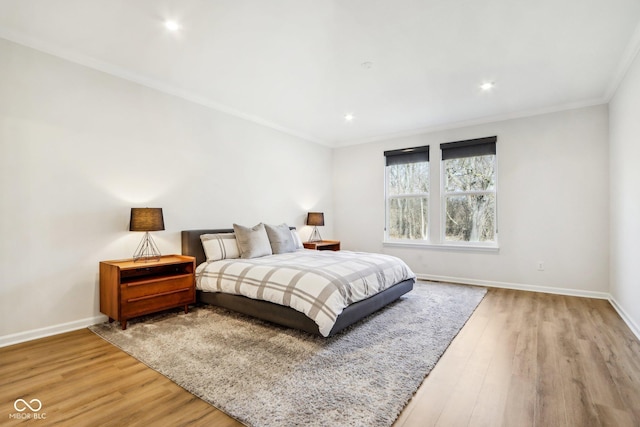 bedroom with ornamental molding and light wood-type flooring