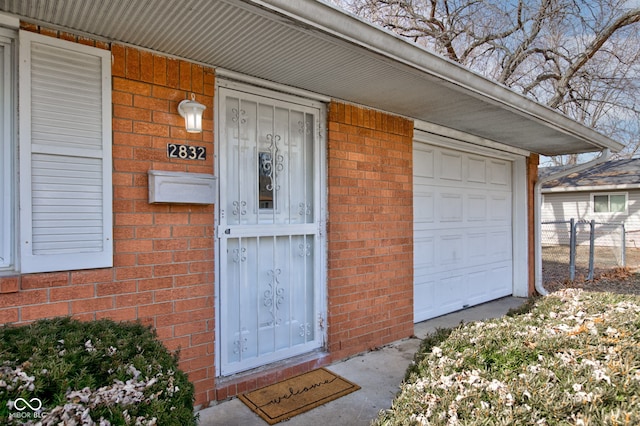 entrance to property featuring fence and brick siding