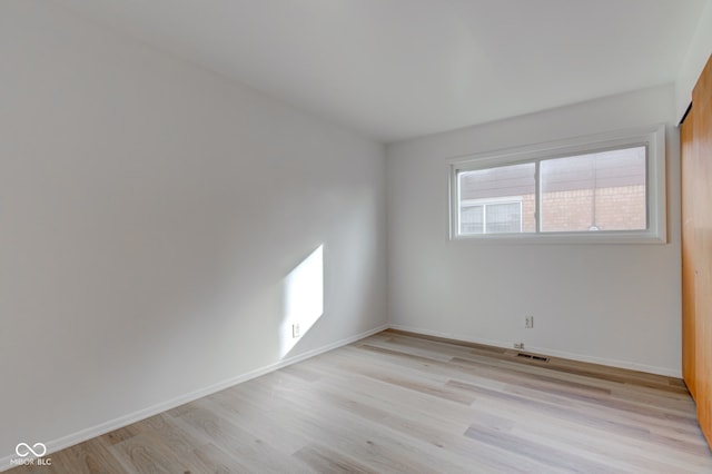 unfurnished room featuring light wood-style floors, baseboards, and visible vents