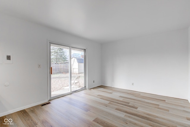 unfurnished room with light wood-style floors and visible vents