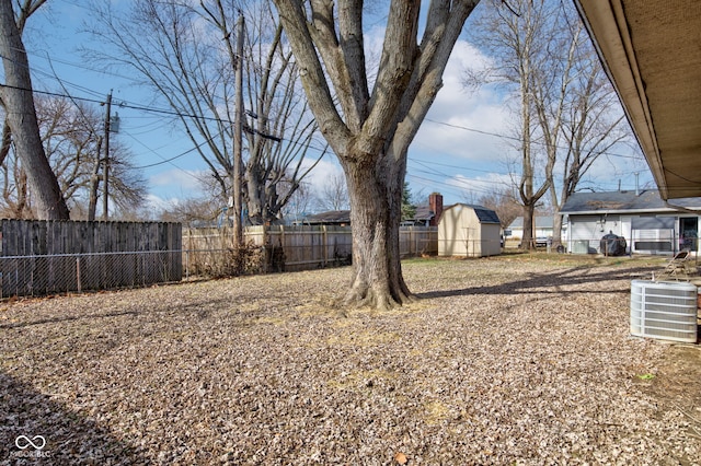 view of yard featuring a storage shed and central air condition unit