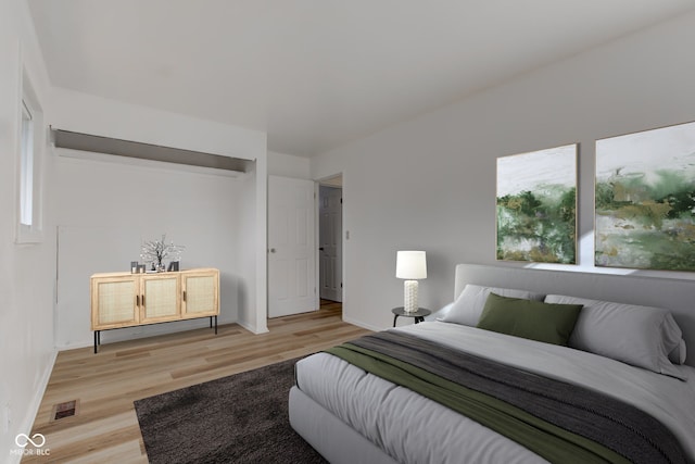 bedroom featuring baseboards, multiple windows, visible vents, and light wood-style floors