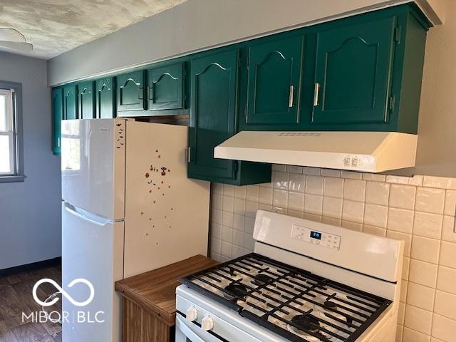 kitchen featuring white appliances, backsplash, green cabinetry, dark hardwood / wood-style flooring, and exhaust hood