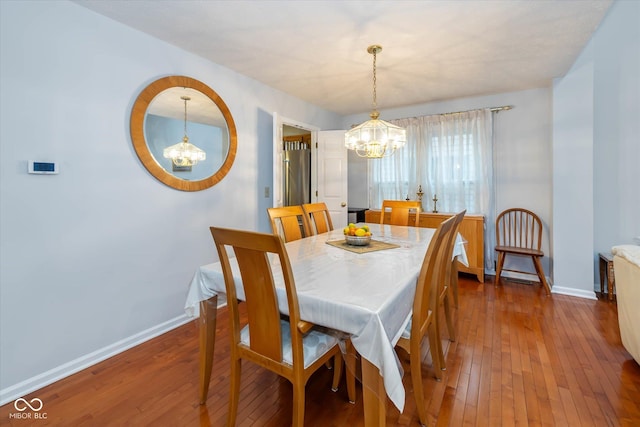 dining area with an inviting chandelier and dark hardwood / wood-style flooring