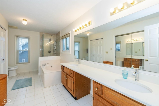 bathroom featuring vanity, tile patterned floors, a tub, and toilet