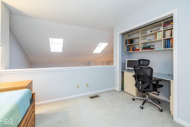 carpeted office space with lofted ceiling with skylight