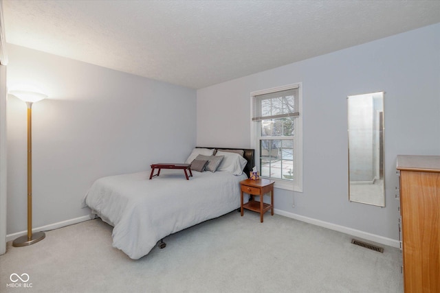 bedroom featuring light carpet and a textured ceiling