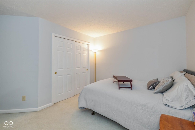 carpeted bedroom with a closet and a textured ceiling