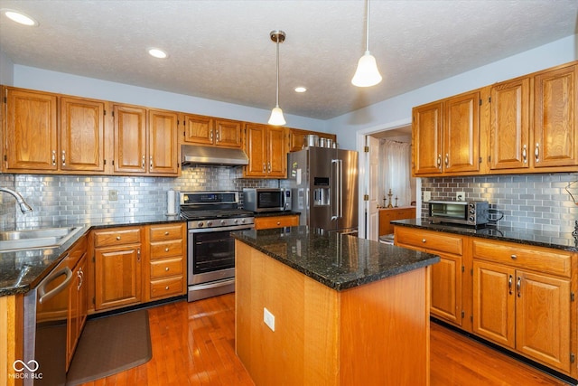 kitchen featuring sink, a center island, hanging light fixtures, dark hardwood / wood-style flooring, and stainless steel appliances