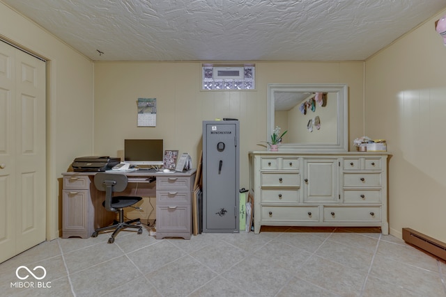 tiled office featuring a baseboard radiator and a textured ceiling