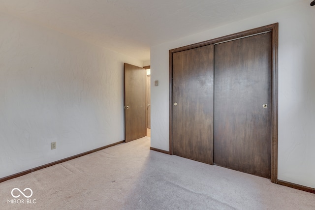 unfurnished bedroom featuring a closet and light carpet