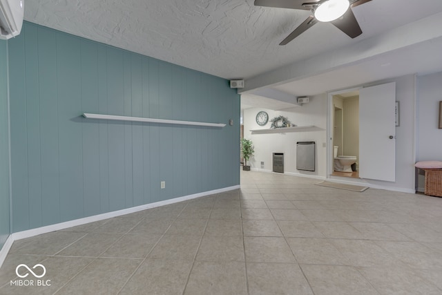 unfurnished living room with ceiling fan, a wall mounted AC, a fireplace, a textured ceiling, and tile patterned floors