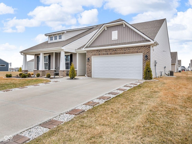 craftsman-style house with a garage, a front yard, covered porch, and cooling unit