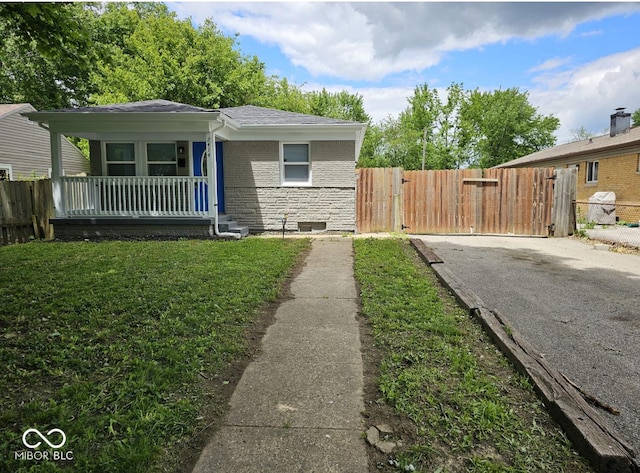 2414 Walker Ave, Indianapolis, IN 46203 - view of front of home with a porch, a gate, driveway, brick siding, and stone siding