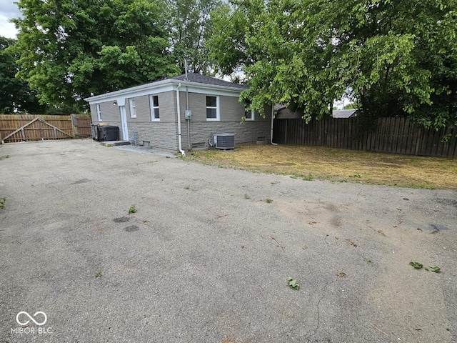 2414 Walker Ave, Indianapolis, IN 46203 - view of side of property with central air condition unit, stone siding, and a gate