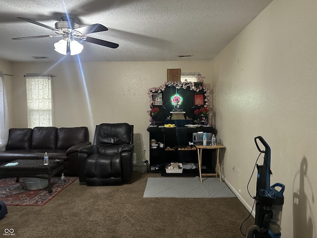 carpeted living room with ceiling fan and a textured ceiling