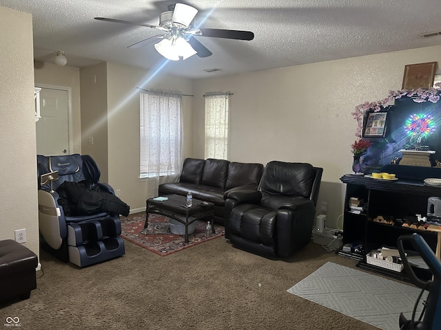 living room featuring ceiling fan, carpet flooring, and a textured ceiling