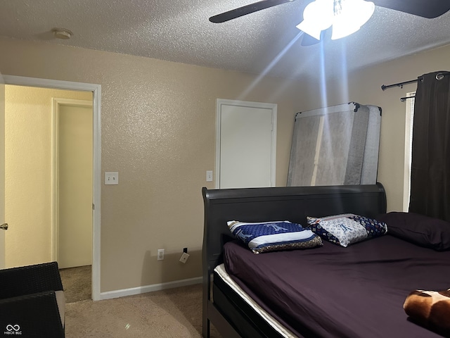 carpeted bedroom with ceiling fan and a textured ceiling