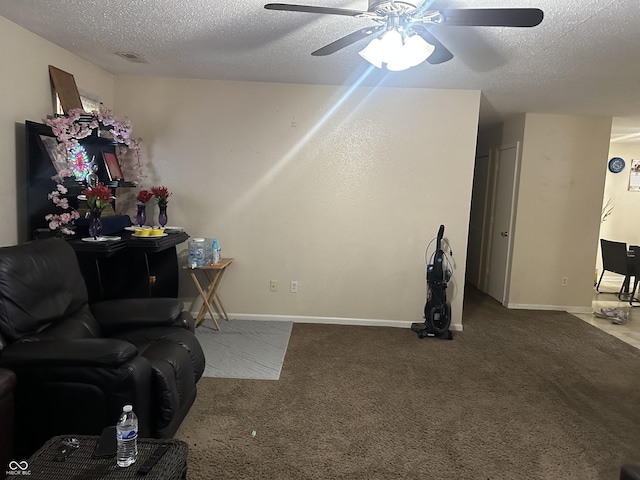 carpeted living room featuring ceiling fan and a textured ceiling