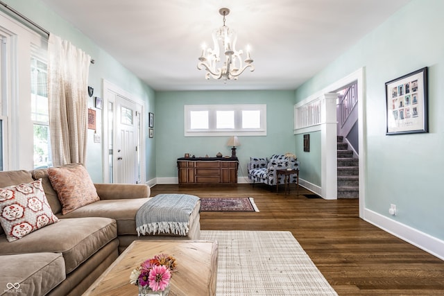 living room with dark hardwood / wood-style flooring and a notable chandelier